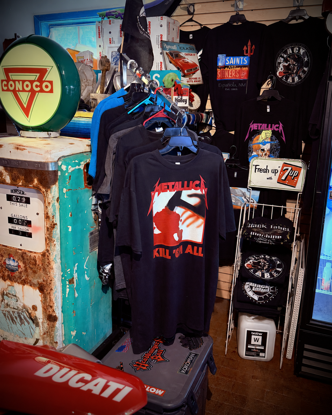 Printed shirt rack beside a vintage Conoco gas pump in the shop