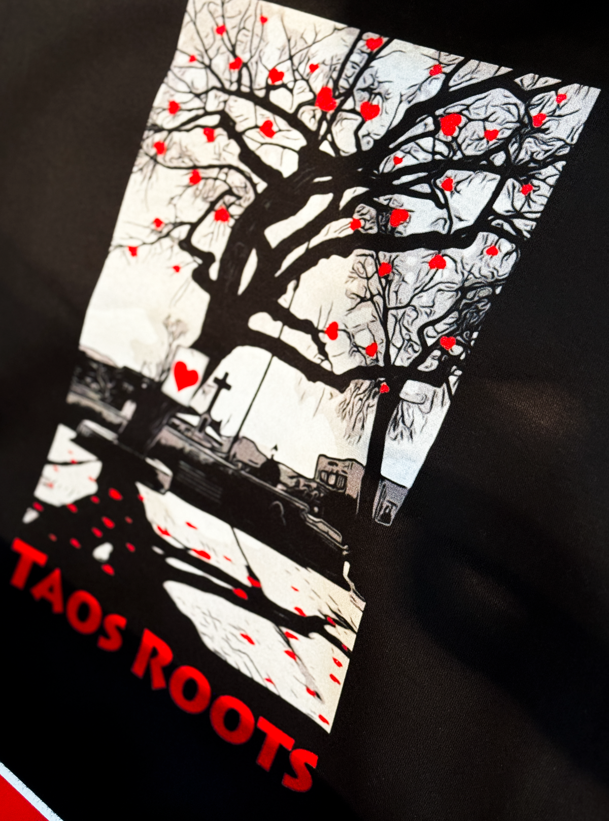 Taos Roots tree artwork with red hearts printed on a black shirt